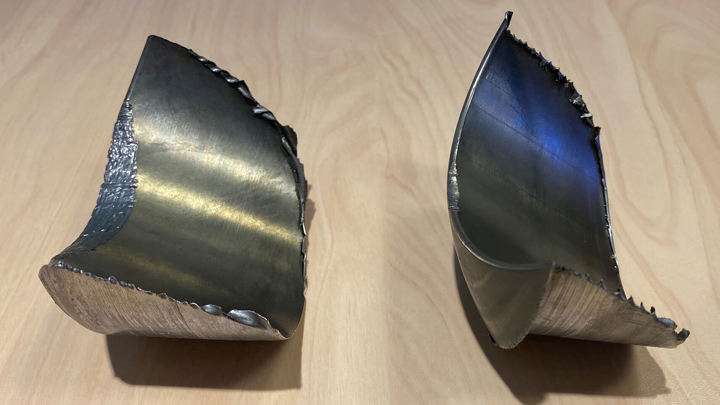 Two metal pipe halves cut with precision using Well Miller showcasing clean internal cuts from downhole well intervention operation          Ask ChatGPT