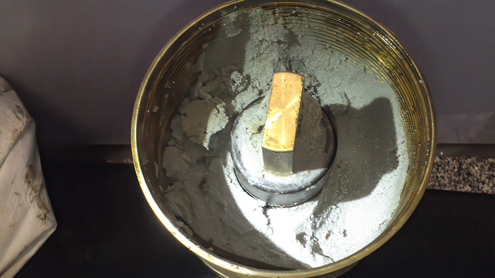 Container holding 1,500 lbs of sand removed during an E-line well intervention, showing successful sand cleanout from the wellbore.