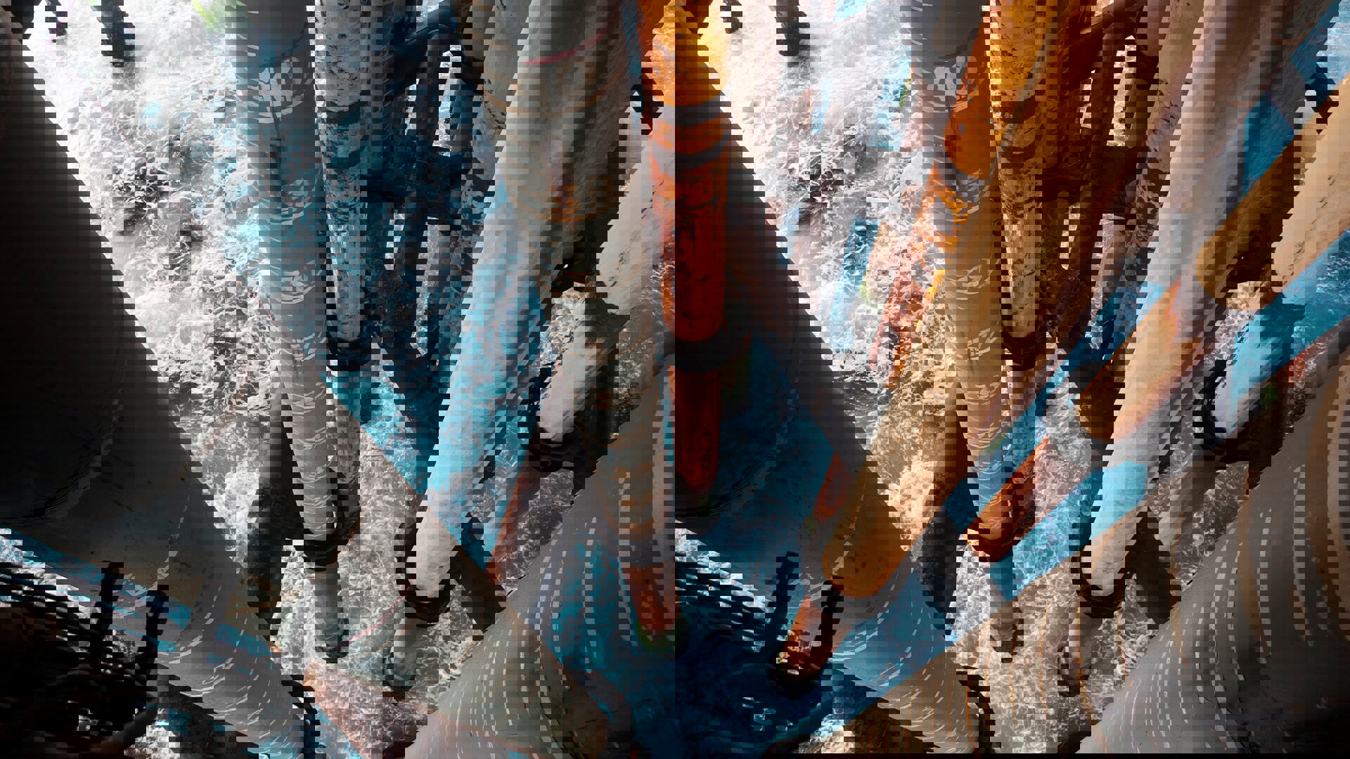 A view of pipes extending into the ocean, partially above water, with gentle waves surrounding them.