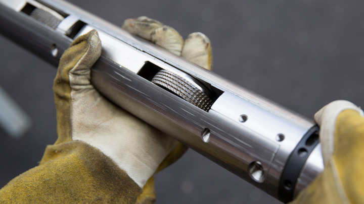 Technician holding a Well Tractor Compact Rig-up tool used for horizontal well intervention.