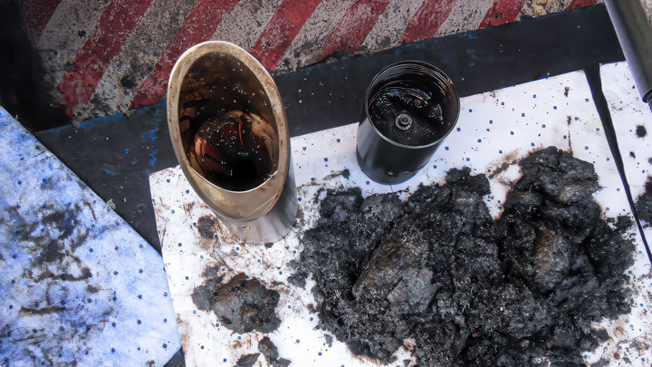 Debris and cut sections from E-Line production tubing and SSSV cleanout operation displayed on a rig floor during well intervention.