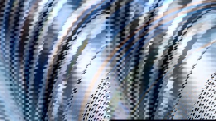 Close up of a Welltec Annular Barrier with alternating silver and dark metal rings used in oil and gas wells to prevent water breakthrough