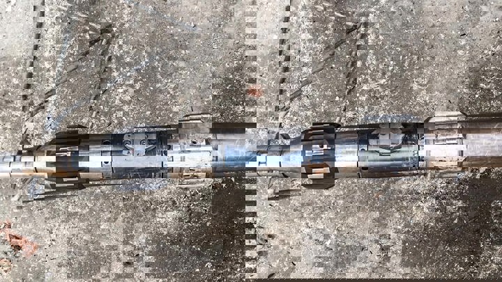 Close-up of Welltec intervention tool on the ground, showing mechanical components.