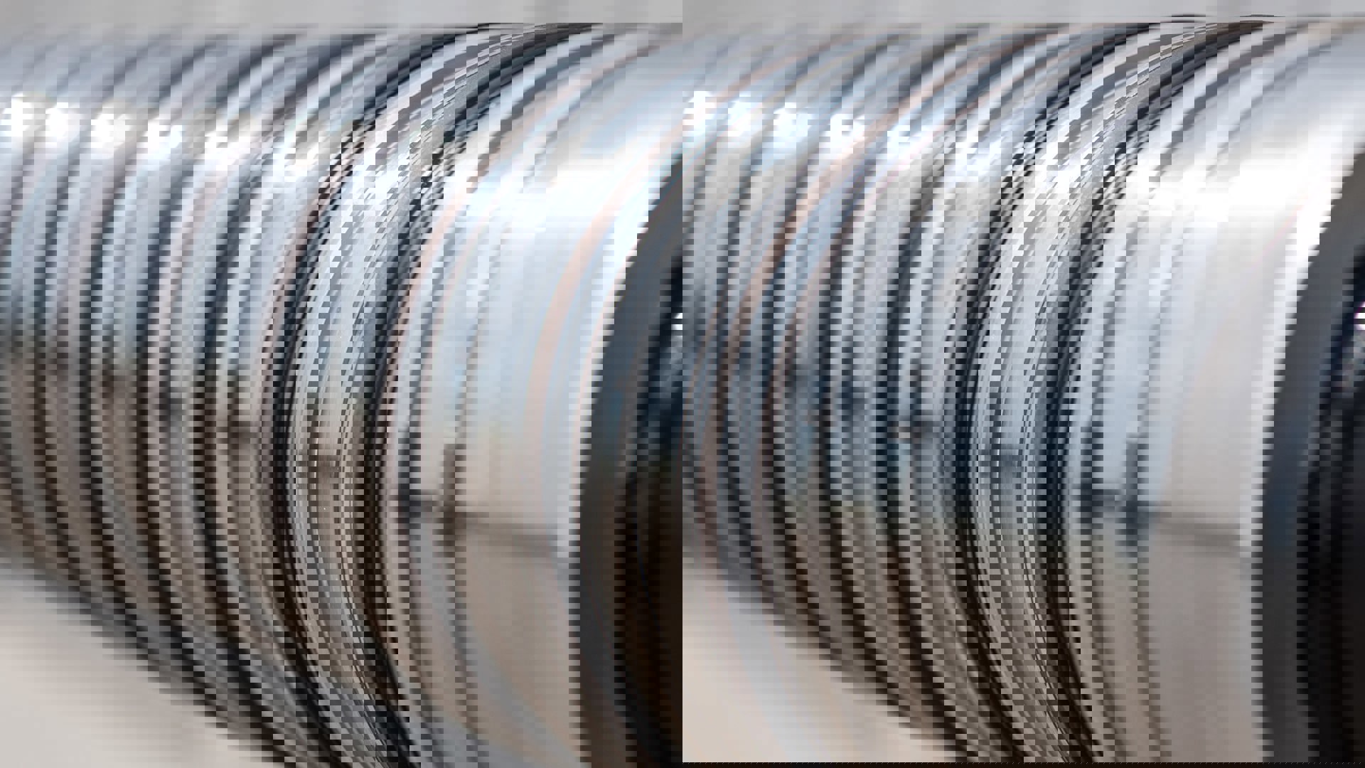 Close-up of Welltec metal components with alternating grooves and seals designed for zonal isolation in well completions.