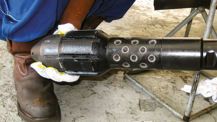 Technician holds an E-line milling tool used in downhole operations to boost production efficiency.