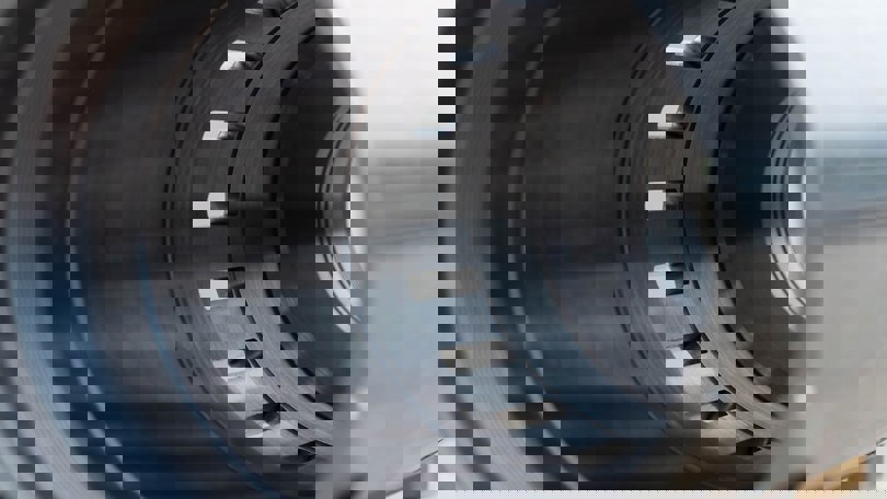 Close-up of a Welltec completion tool showing detailed metal grooves and precision-engineered components for wellbore isolation.