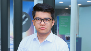 Joven John R. Cayao, Geothermal Technical Sales Engineer - Completion, standing in front of a Welltec display with a professional expression.