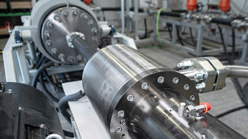 Close up of a high pressure test loop setup with flanged metal tubing and hydraulic fittings used for equipment testing in a controlled lab environment.