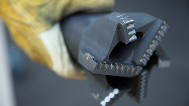 Well Cleaner RCB tool held by gloved hand, designed to clear lateral obstruction for toe perforation operations in North Dakota.