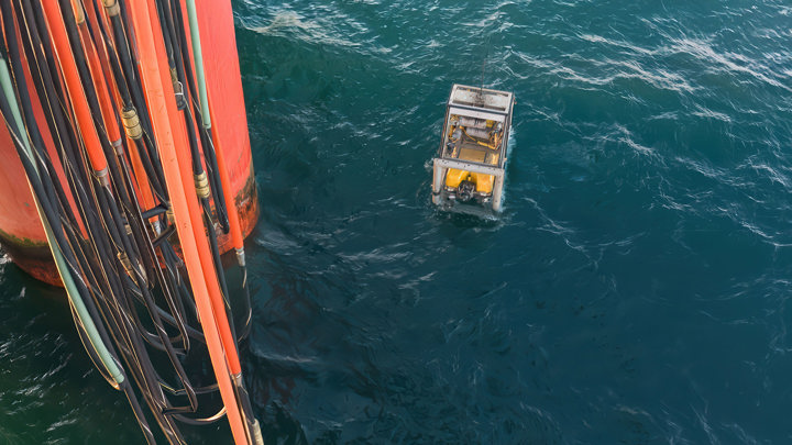 Offshore view of RLWI operation retrieving asphaltenes, with equipment deployed near a rig, setting a water depth record during well intervention.