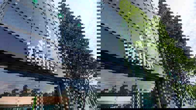 Exterior shot of the Welltec headquarters building with modern glass architecture, featuring the Welltec logo prominently on the facade.